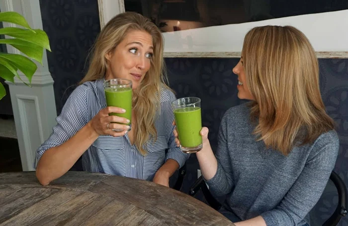 Două femei frumoase care stau la o masă și beau smoothie cu spanac Captură video YouTube