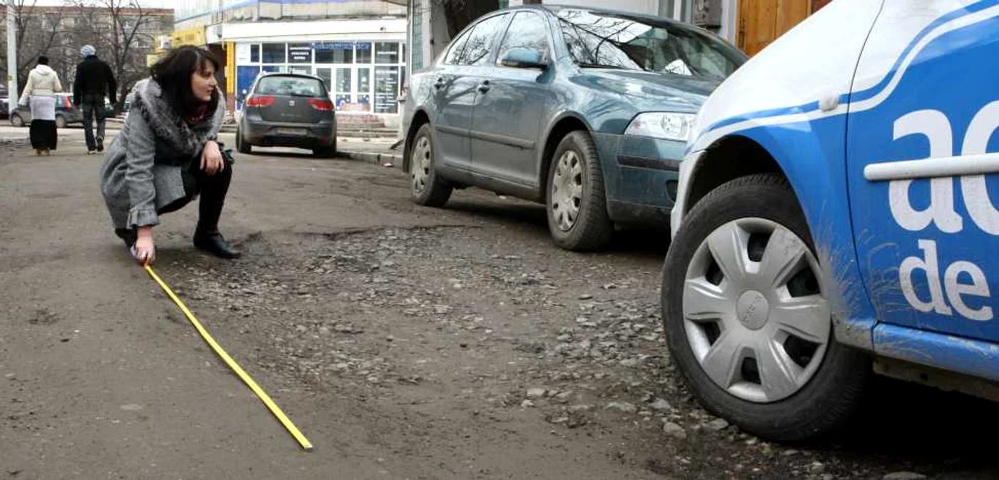 Şoferii spun că li se rupe maşina când trec prin groapa de pe strada Democraţiei Foto: Corina Tătaru