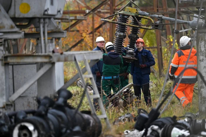 Muncitori ucraineni repară liniile elctrice afectate de o lovitură a rușilor Foto AFP