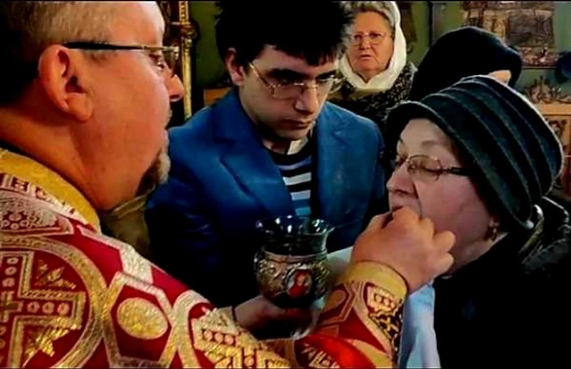 Preotul din Sibiu împărtăşeşte o enoriaşă direct cu mâna FOTO Facebook