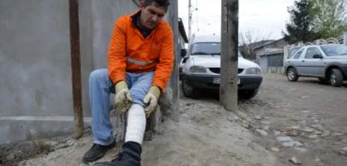 Craiova: Tiberiu Pârvu cară gunoaiele, având piciorul bandajat.