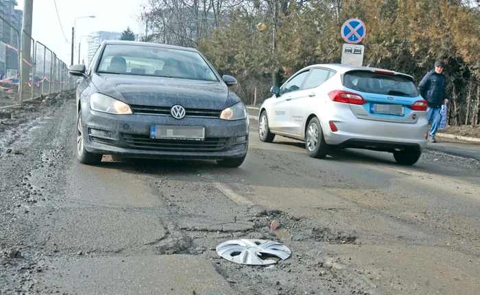 
    Pe strada Fabrica de Glucoză, o groapă a făcut o”victimă”, un capac de roatăFoto: Florin Şuler  