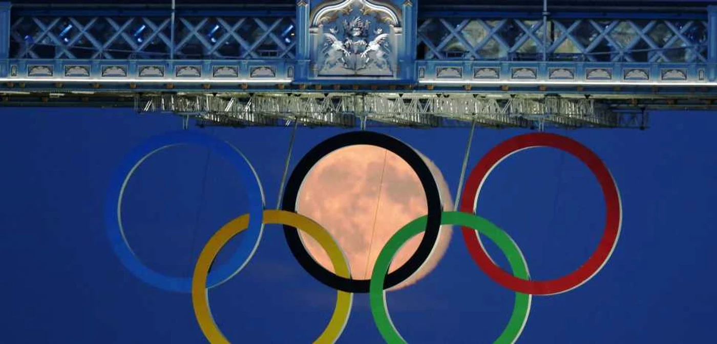 Imagine inedită cu luna plina între cercurile olimpice. FOTO Reuters/LUKE MACGREGOR