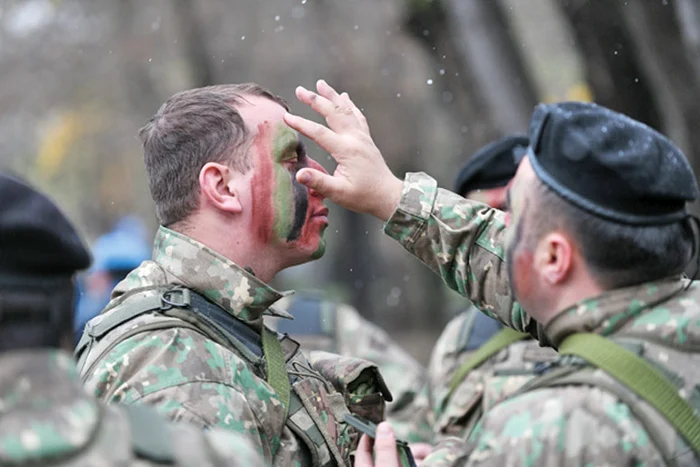 Un militar își ”machiază” camaradul pentru paradă