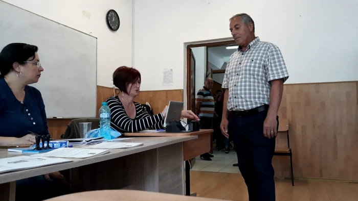 secție de votare cu un cetatean care asteapta verificarea buletinului inainte de a vota