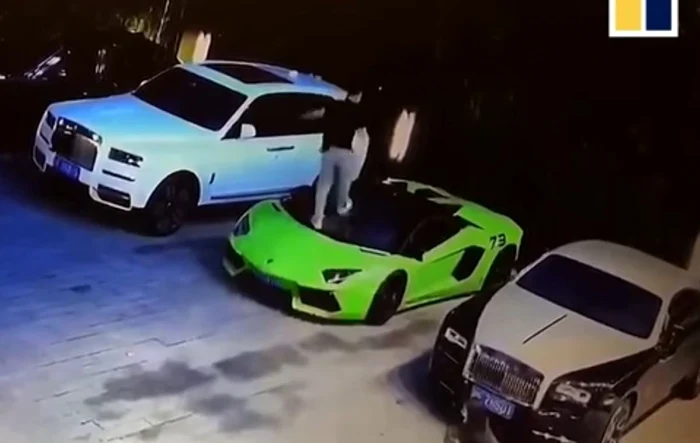 Un tânăr stă în picioare pe o mașină verde luxoasă, decapotabilă