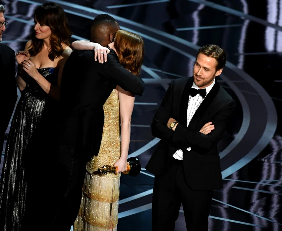 Actriţa Emma Stone („La La Land“), îmbrăţişându-l pe actorul Mahershala Ali („Moonlight“), în timp ce Ryan Gosling („La La Land“) pare amuzat de situaţie FOTO Guliver/Getty Images
