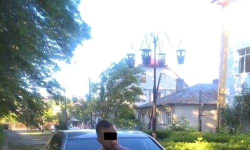 Hoţul ieşean s a pozat cu telefonul furat de la un danez, rezemat de o maşină în care se vede clar plăcuţa de înmatriculare jpeg