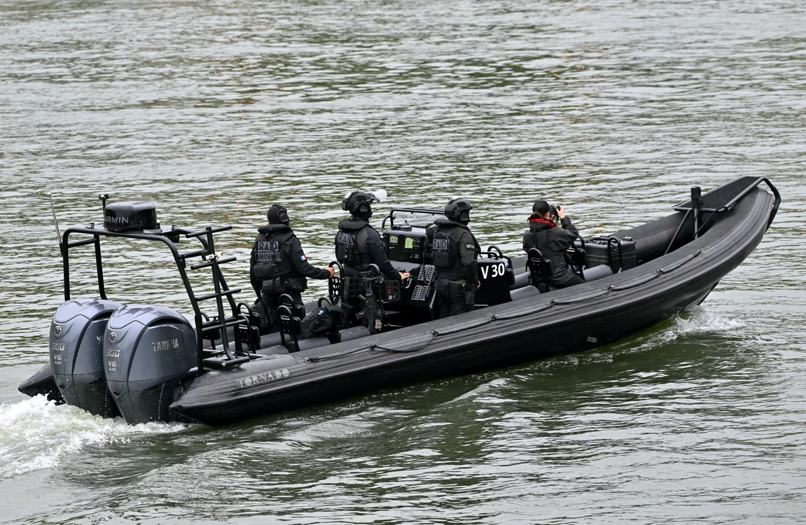 Unitate de poliție patrulând pe Sena înainte de startul ceremoniei. Foto AFP