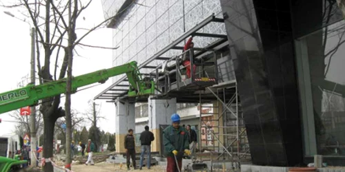 Muncitorii lucrează de zor la ultimele finisări a zonei pietonale de lângă Atrium Center