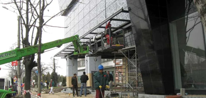 Muncitorii lucrează de zor la ultimele finisări a zonei pietonale de lângă Atrium Center