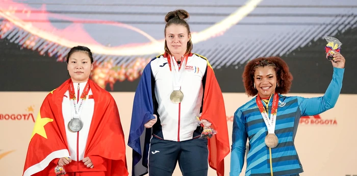 Loredana Toma (centru) pe podiumul mondial. FOTO: Facebook / Federația Română de Haltere