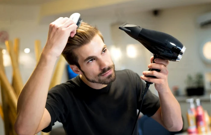 Păr sănătos cu o rutină de haircare corectă / bărbat care își aranjează părul Foto Salt Grooming