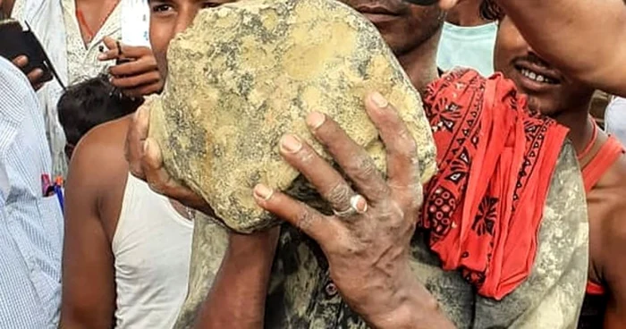 Un sătean din India ţină în mână un posibil meteorit