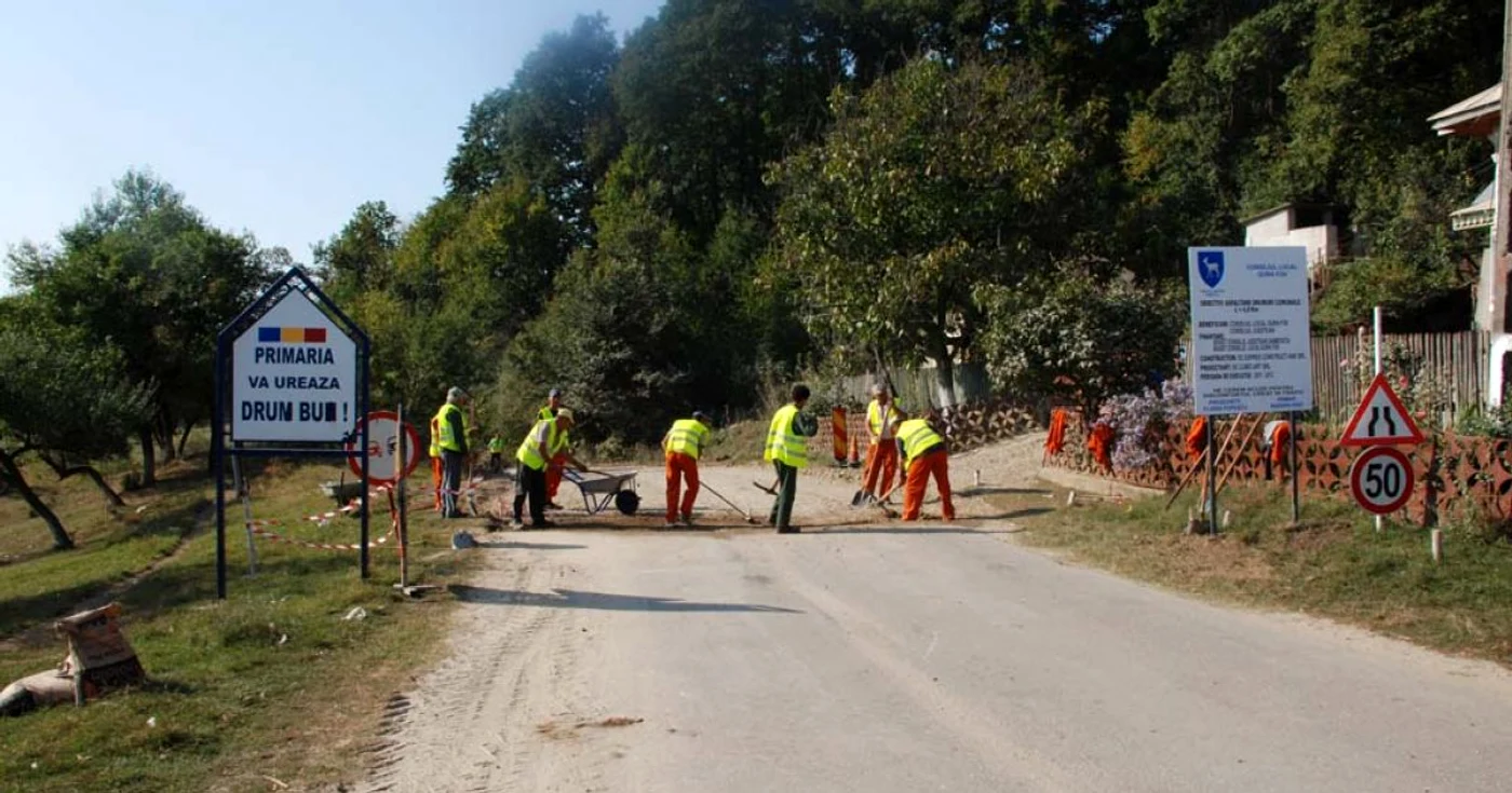 Muncitori care repară un drum